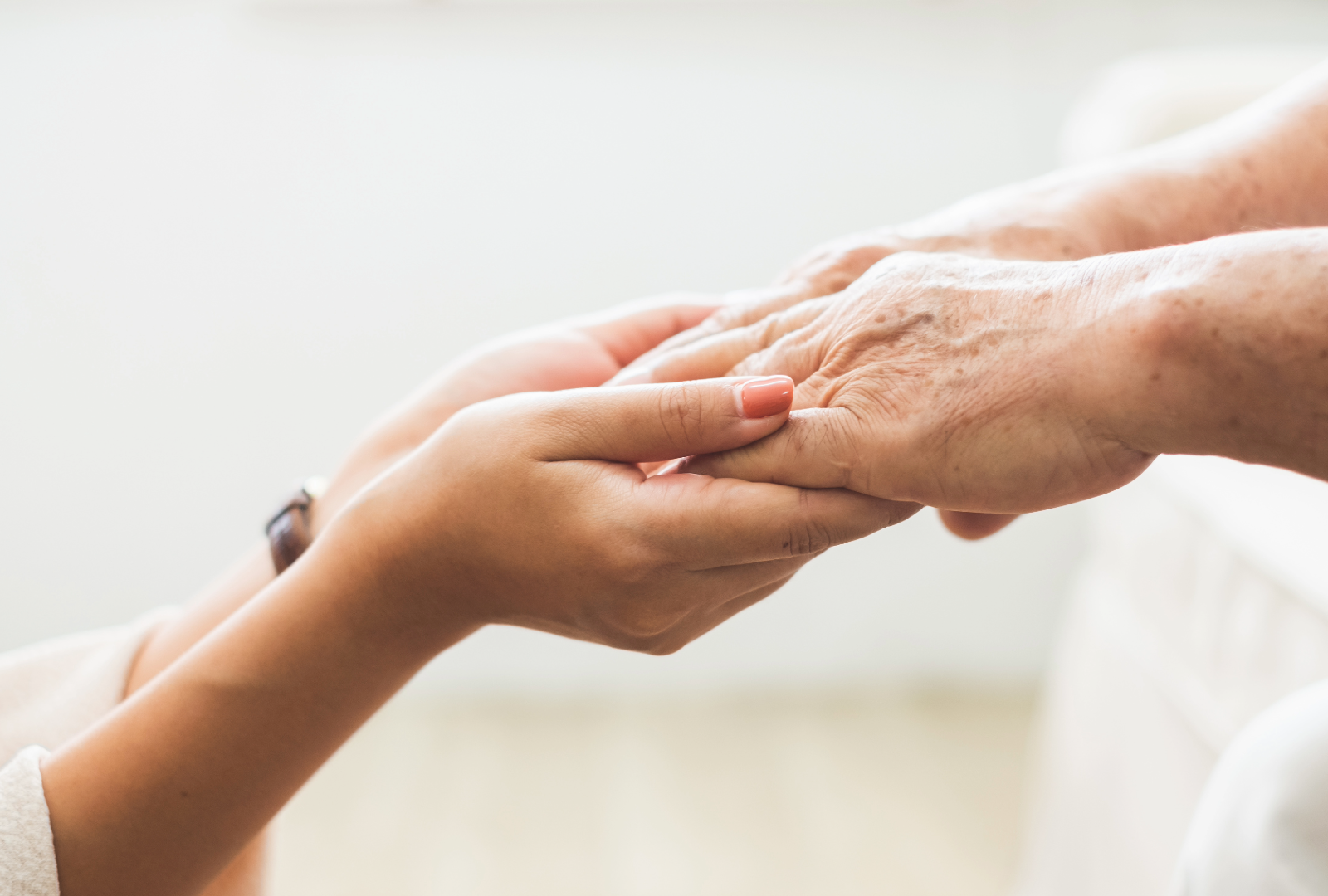 A woman's hands holding her elderly mother's hands in Guelph, ON.